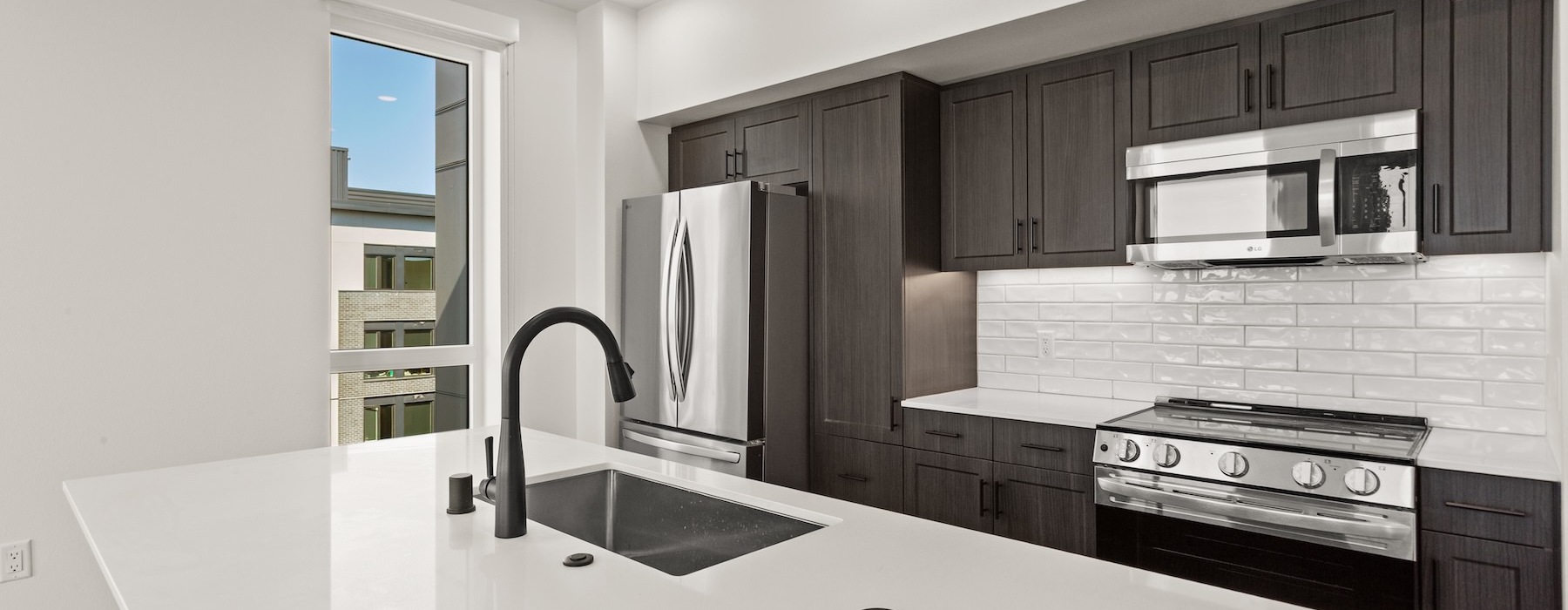 a kitchen with dark cabinets