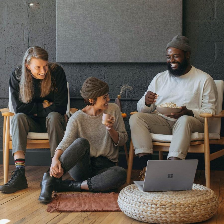 friends sit together around an open laptop